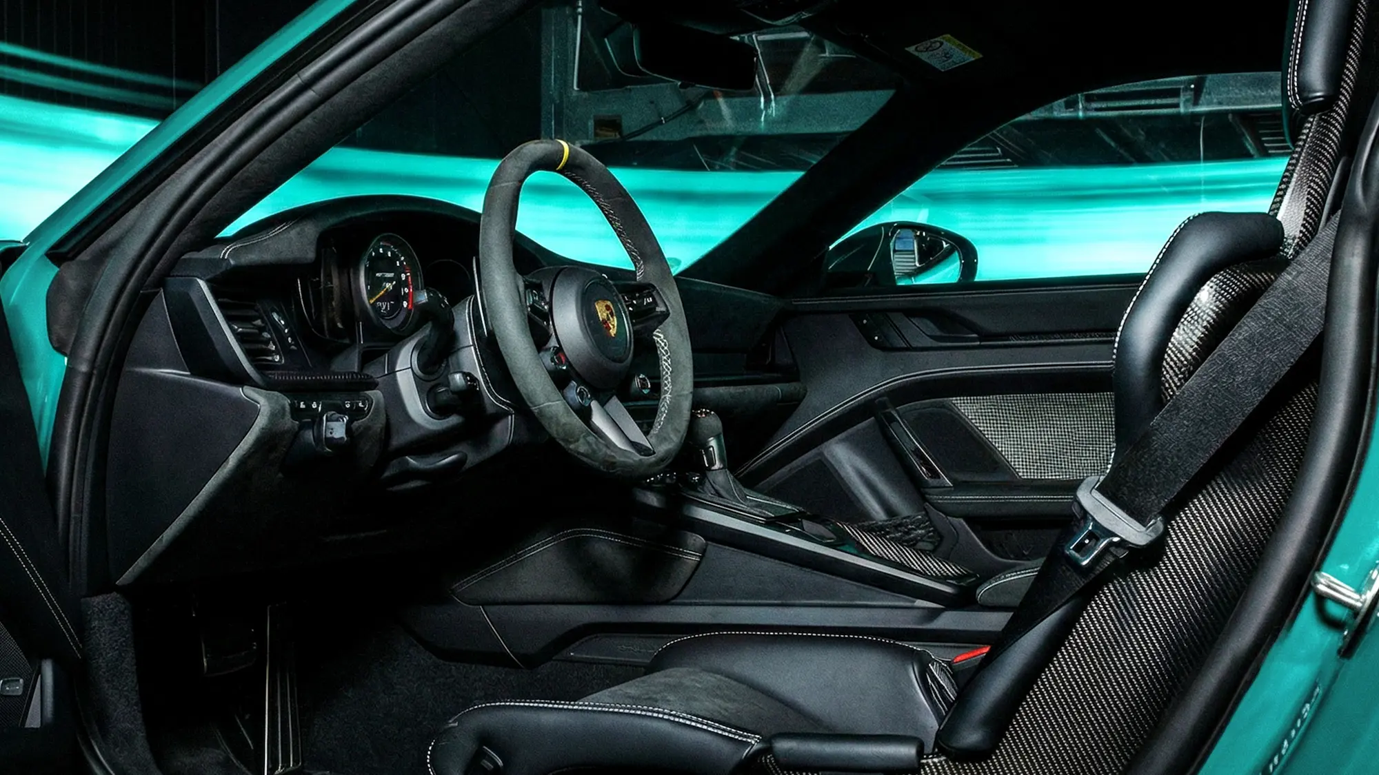 Innenraum des Porsche 911 GT3 RS mit Alcantara-Lenkrad, Carbon-Elementen und Rennsitz mit 6-Punkt-Gurt